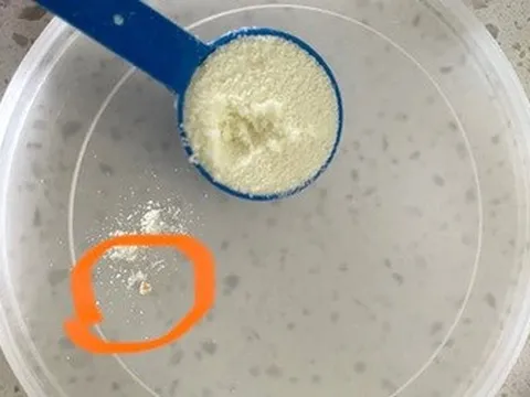 Vì sao xuất hiện những hạt sậm màu lắng trong ly sữa bột?