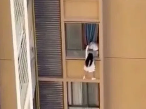 Cô gái trèo tường chung cư để trốn vợ tình nhân gây sốc ở Trung Quốc